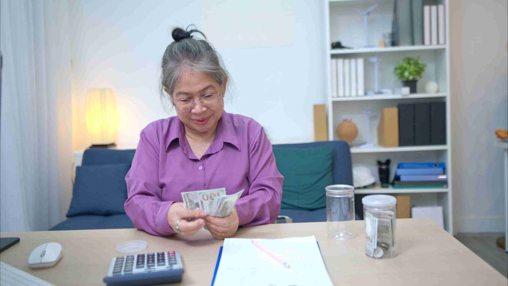Elderly woman counting money for a medical procedure.
