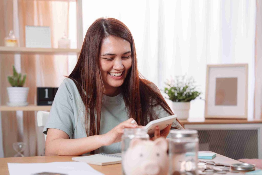 Woman smiling while holding a calculator.
