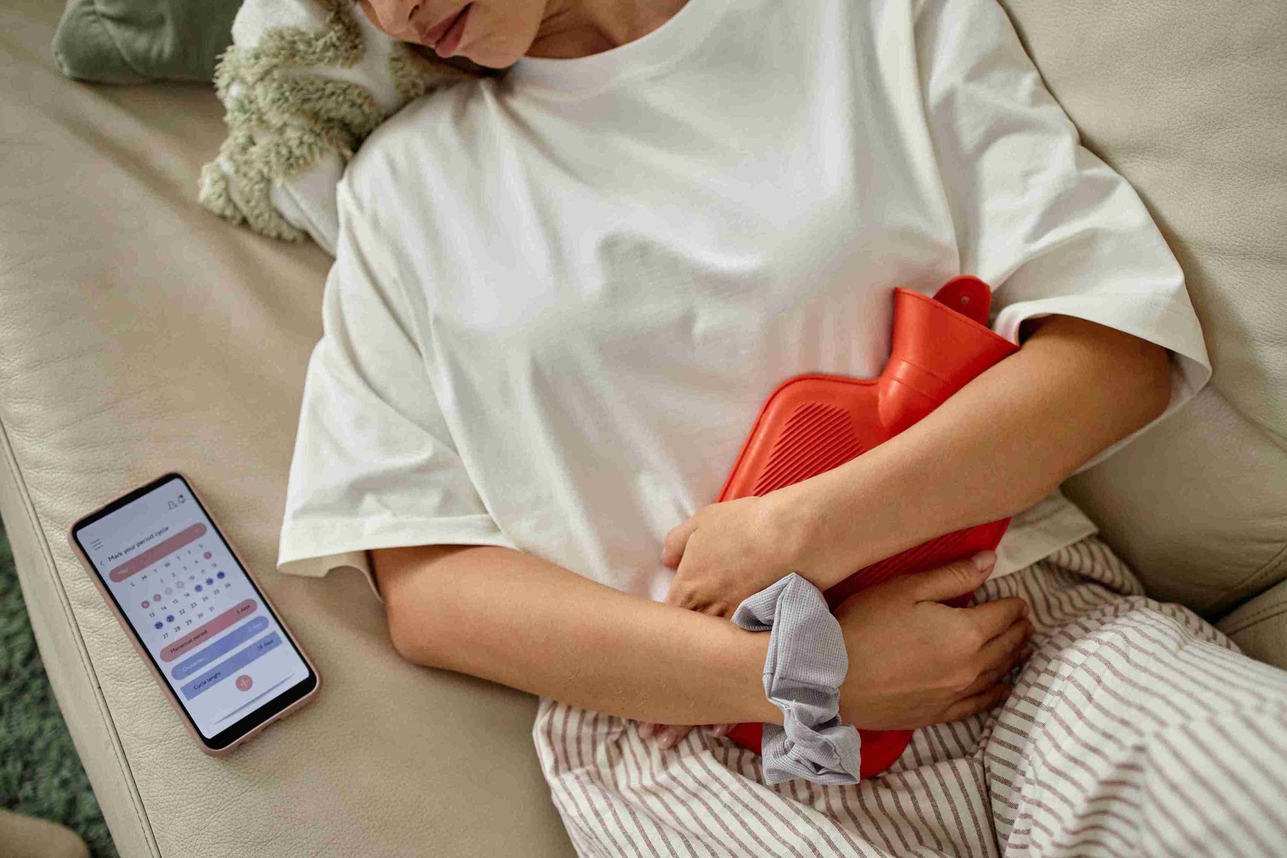 Woman lying on the bed with menstrual cramps.