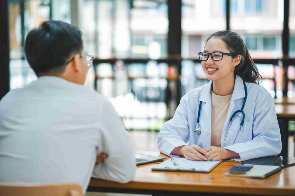 Young female doctor smiling while talking to her patient.