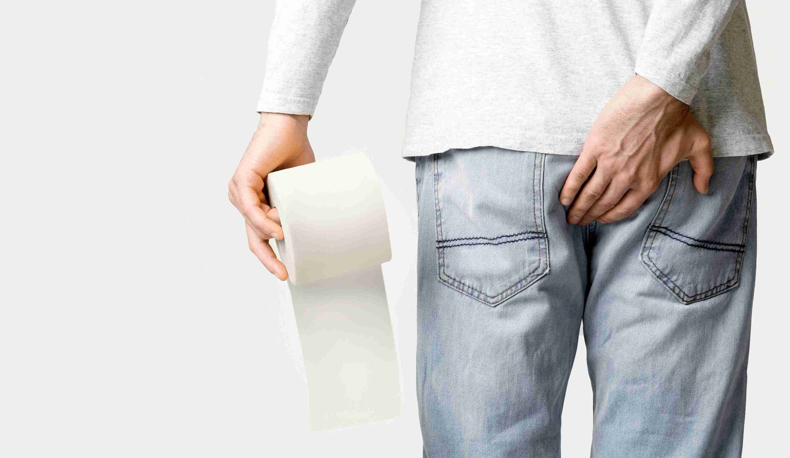 Person holding a toilet paper on his left hand and his right hand on his butt.