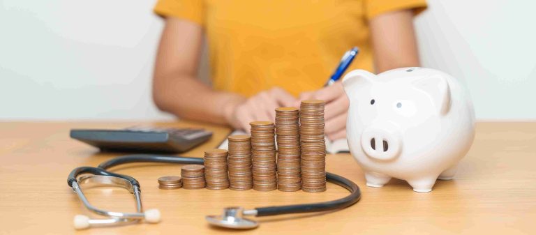 Woman with coins and piggy bank with stethoscope.