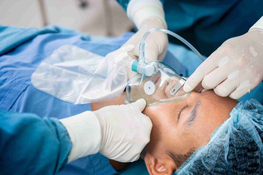 Patient wearing a ventilator oxygen mask in preparation for surgery.