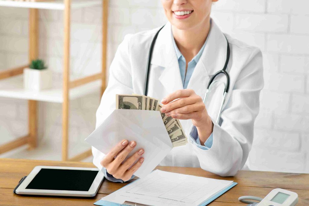 Doctor counting dollar bills in a white envelope.