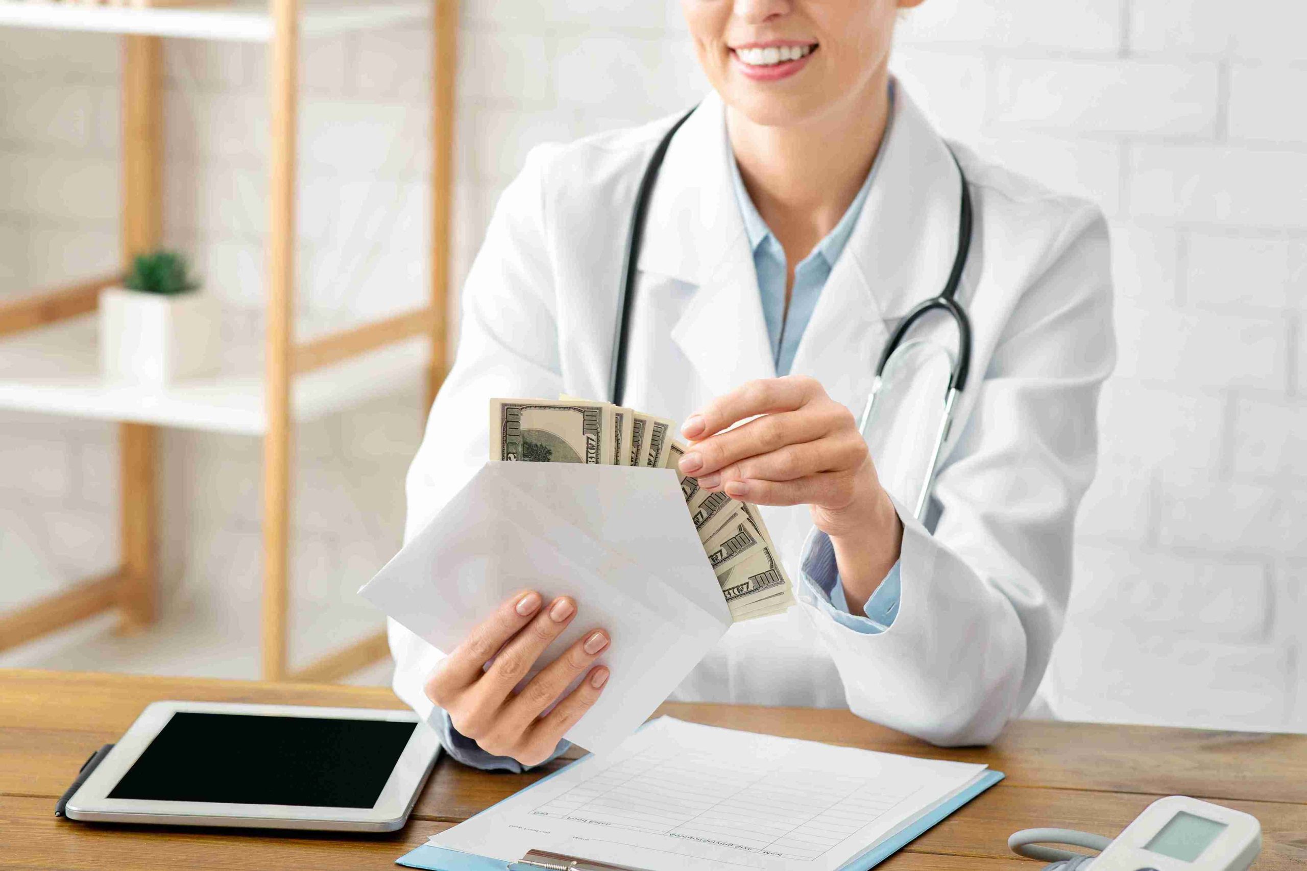 Doctor counting dollar bills in a white envelope.